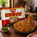 Nissin Yakisoba 100 g with prepared yakisoba noodles in a warm kitchen